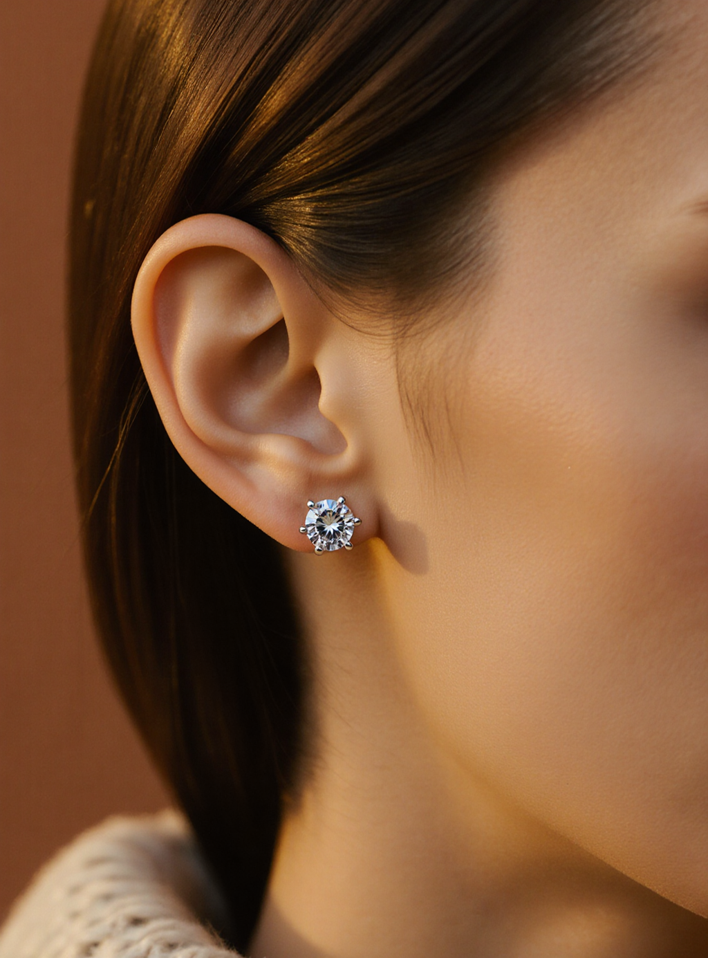 Close-up of an ear wearing a moissanite earring with a blurred background