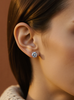 Close-up of an ear wearing a moissanite earring with a blurred background