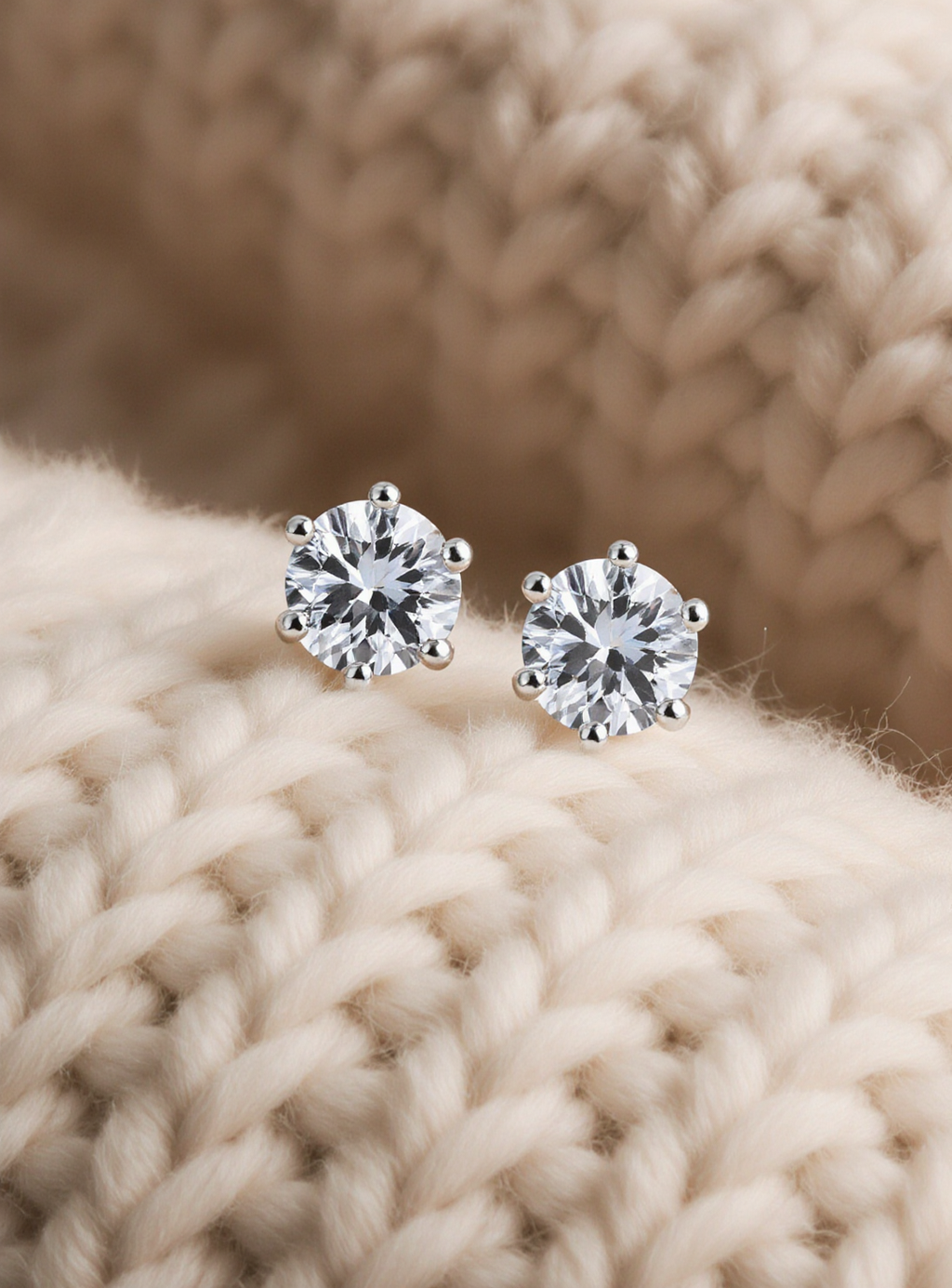 moissanite stud earrings on a beige knitted fabric background