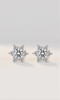 Star-shaped silver earrings with clear gemstones on a light gray background