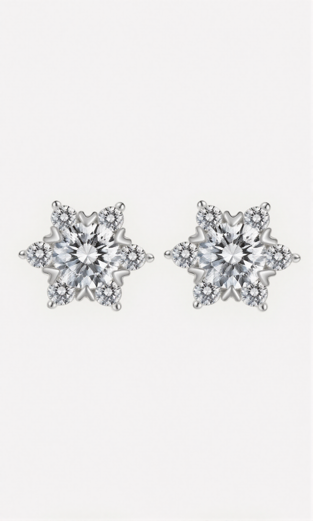 Pair of silver star-shaped earrings on a light gray background