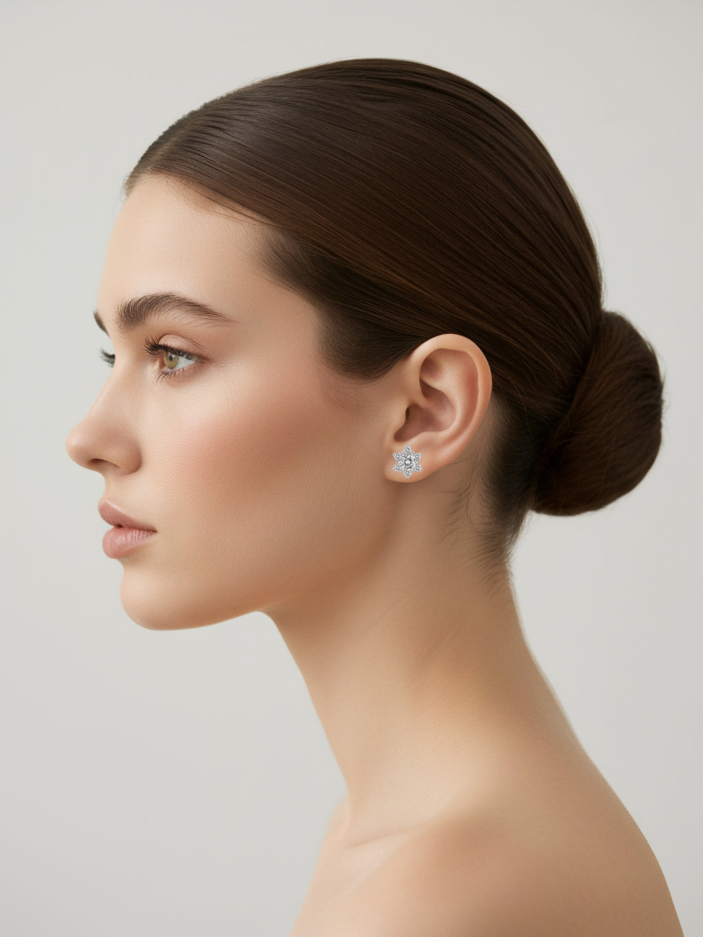 Woman wearing moissanite earrings with a neutral background