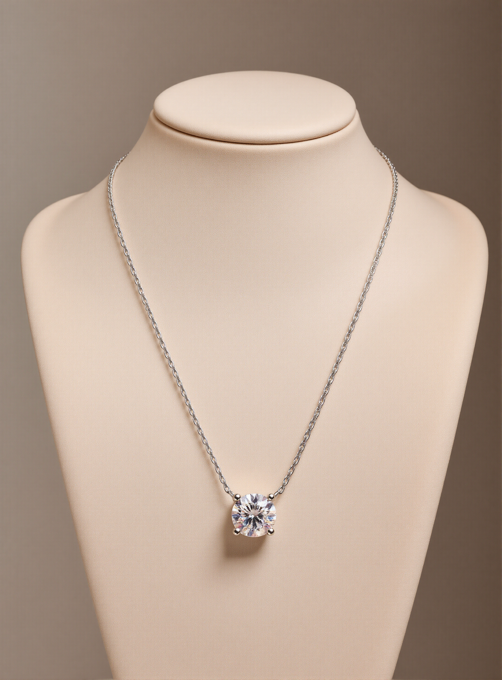 Silver necklace with a moissanite pendant on a mannequin bust against a beige background