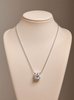 Silver necklace with a moissanite pendant on a mannequin bust against a beige background