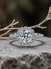 moissanite ring with floral halo on a stone surface with blurred natural background